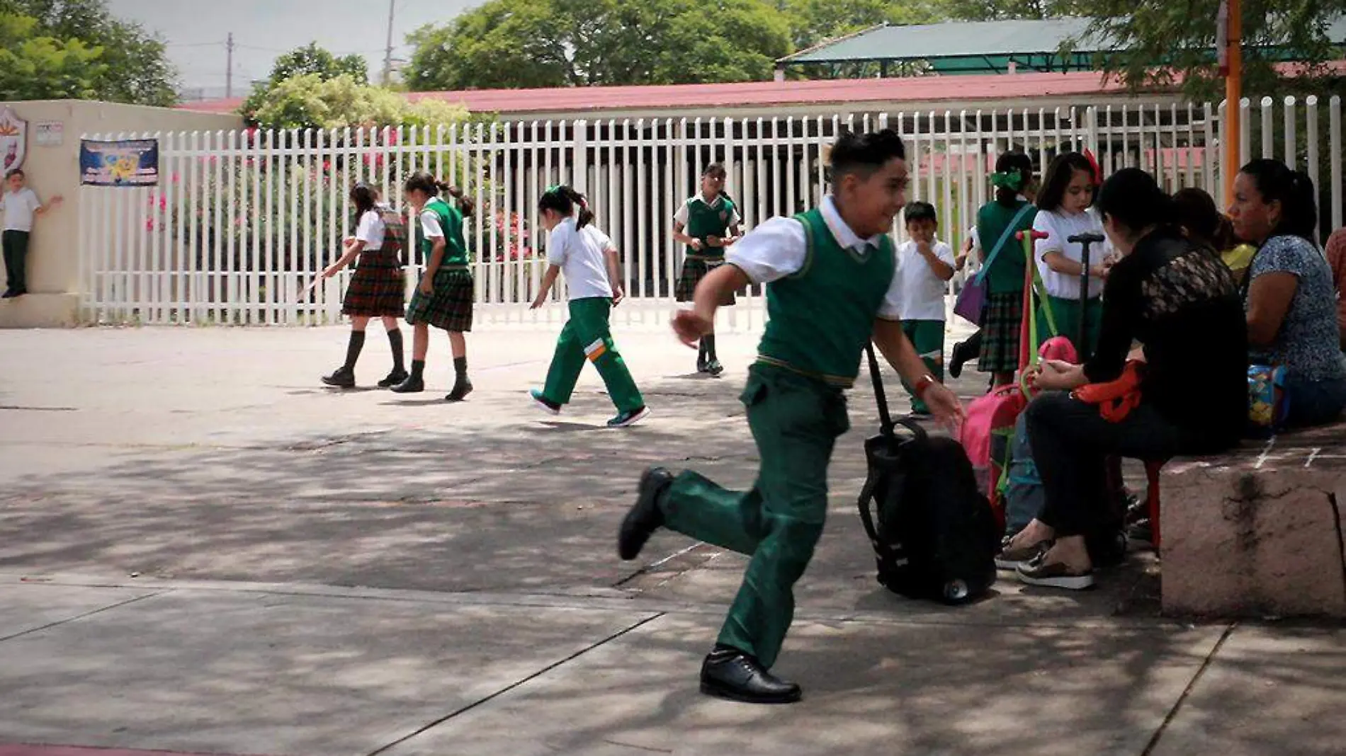 Niños corriendo afuera de la escuela